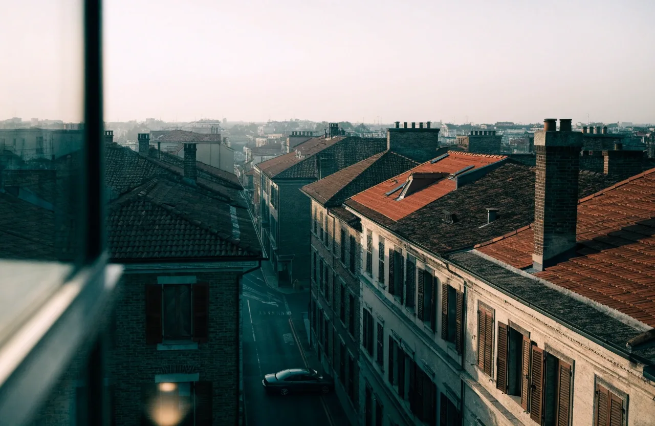 Tetti di Milano all'alba visti da una finestra di ufficio al piano alto